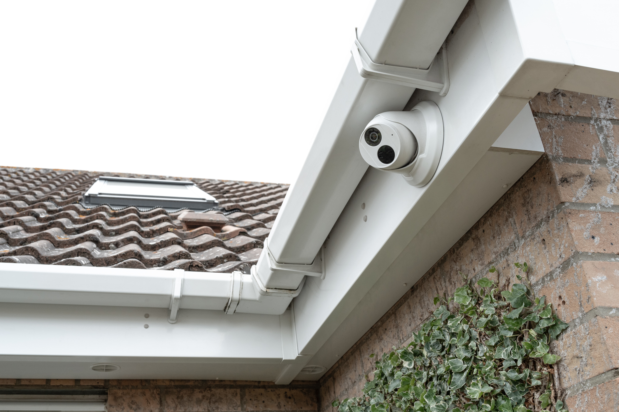 Newly installed dome wireless security cameras fitted to the eaves of a modern house, located on a housing estate in the UK.