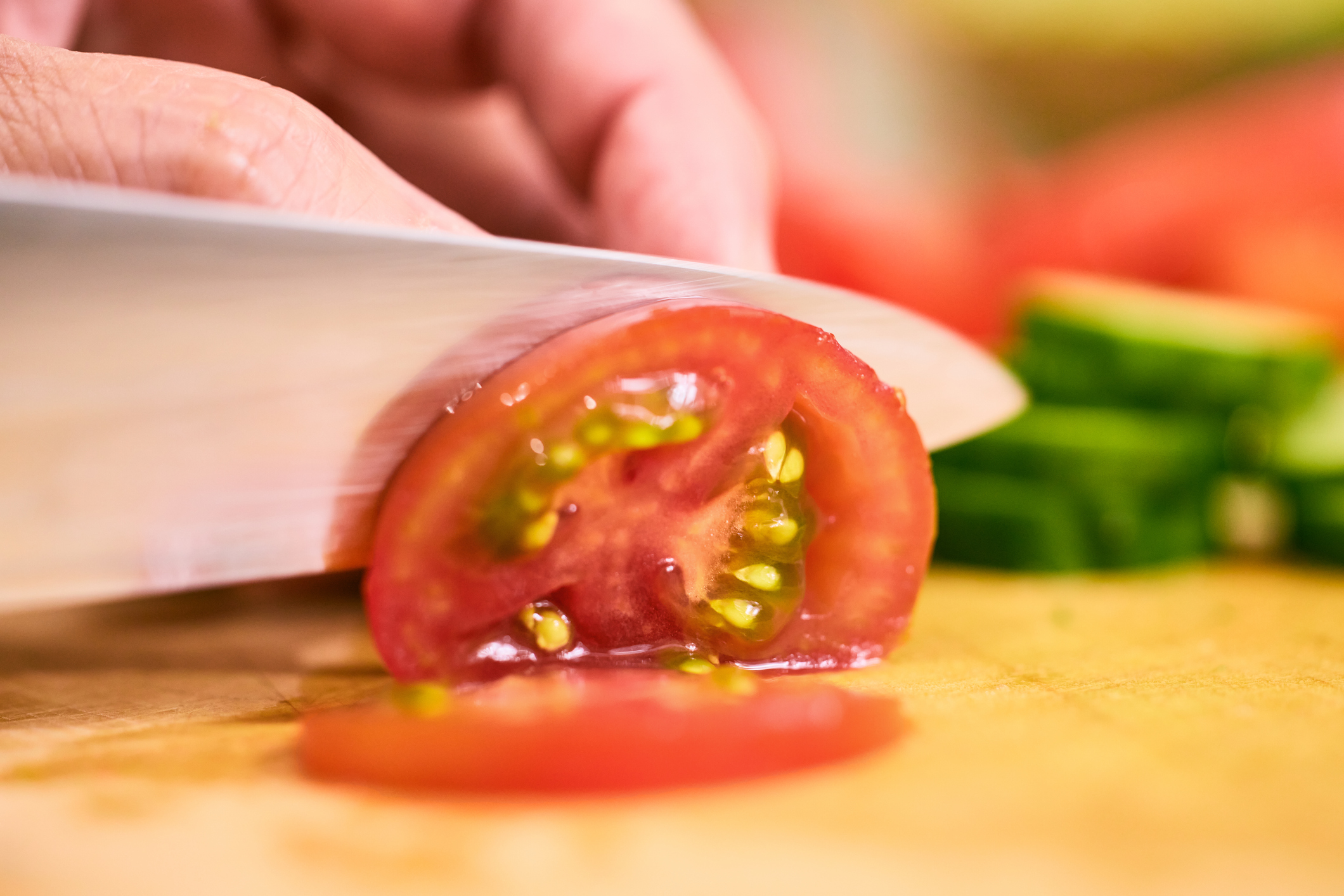 hand slicing tomato rings with Western knife