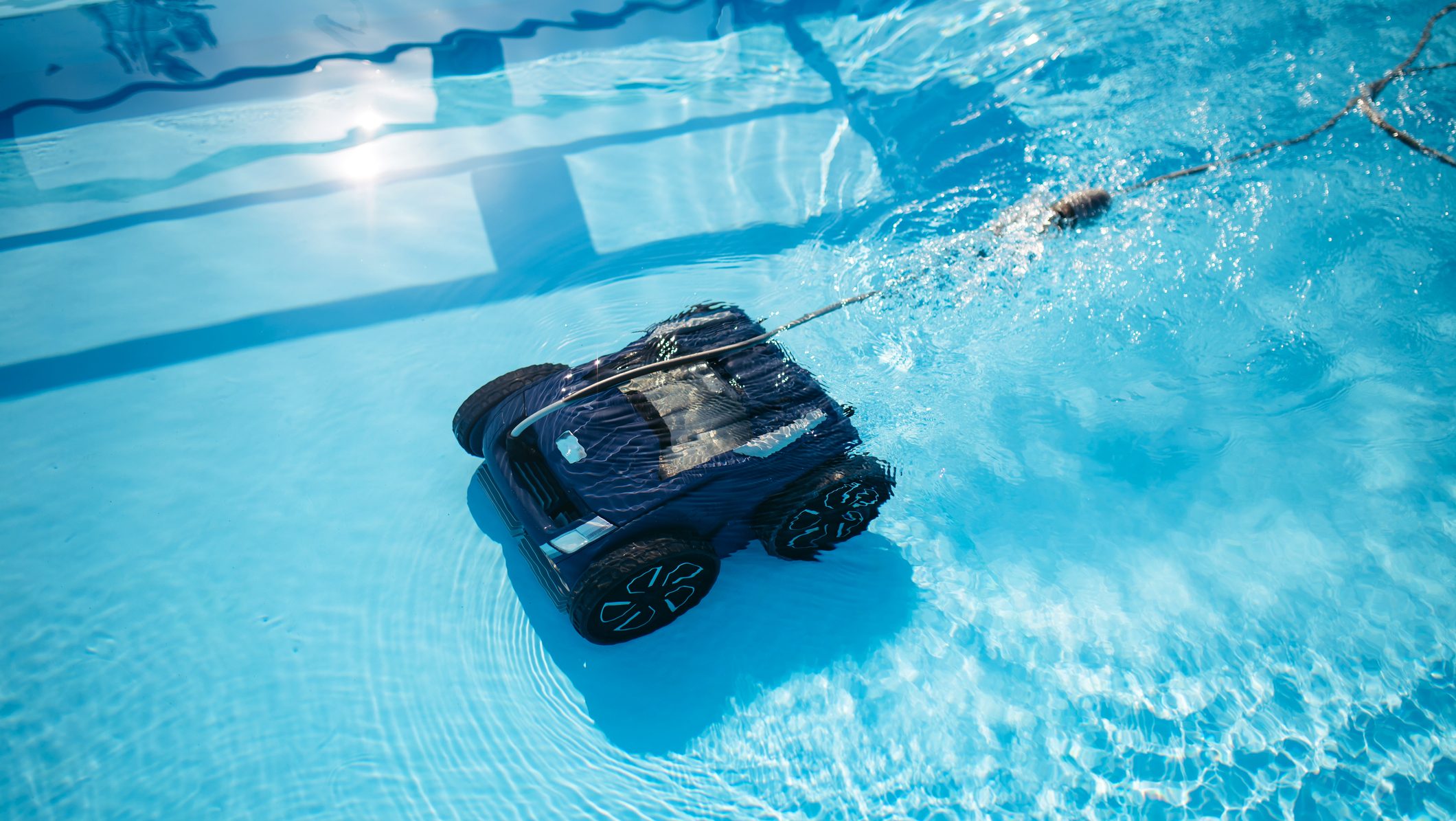 Robotic pool cleaner working underwater to keep swimming pool clean.. Smart underwater pool vacuum robot.