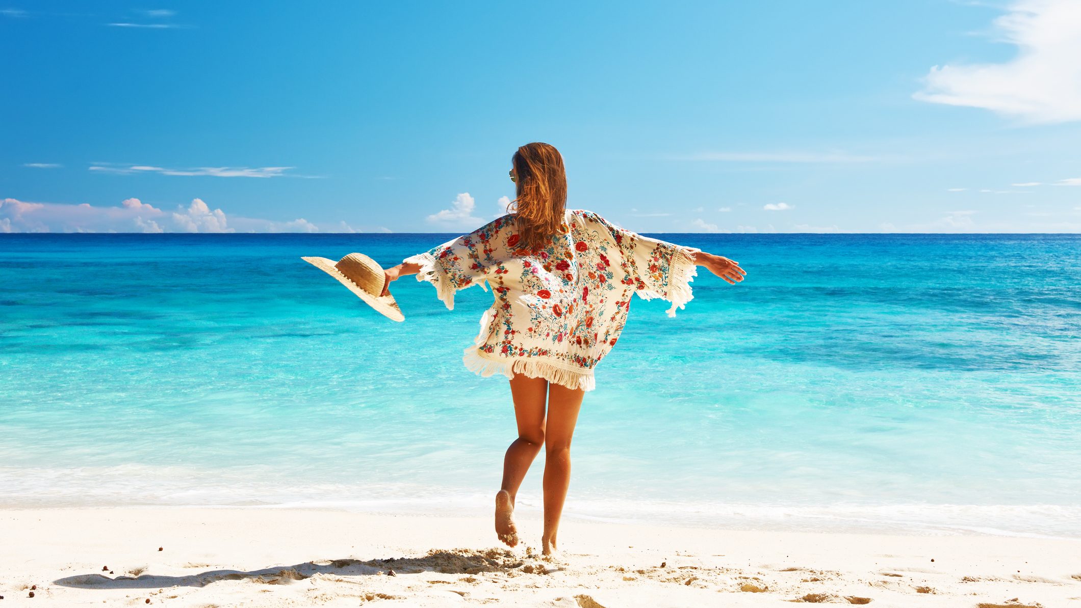 Woman with sarong on beach Anse Intendance at Seychelles, Mahe