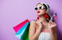 woman in sunglasses with flag and shopping bags on purple background