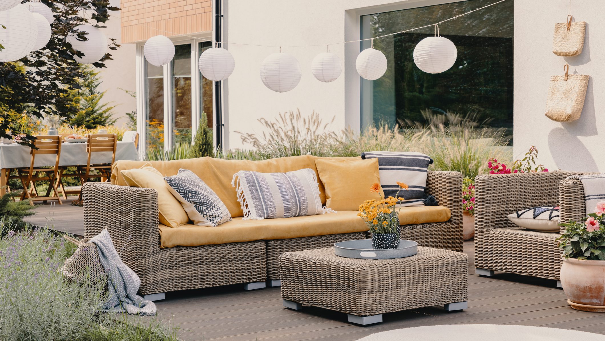 Real photo of a rattan garden furniture set with lamps and table in the background