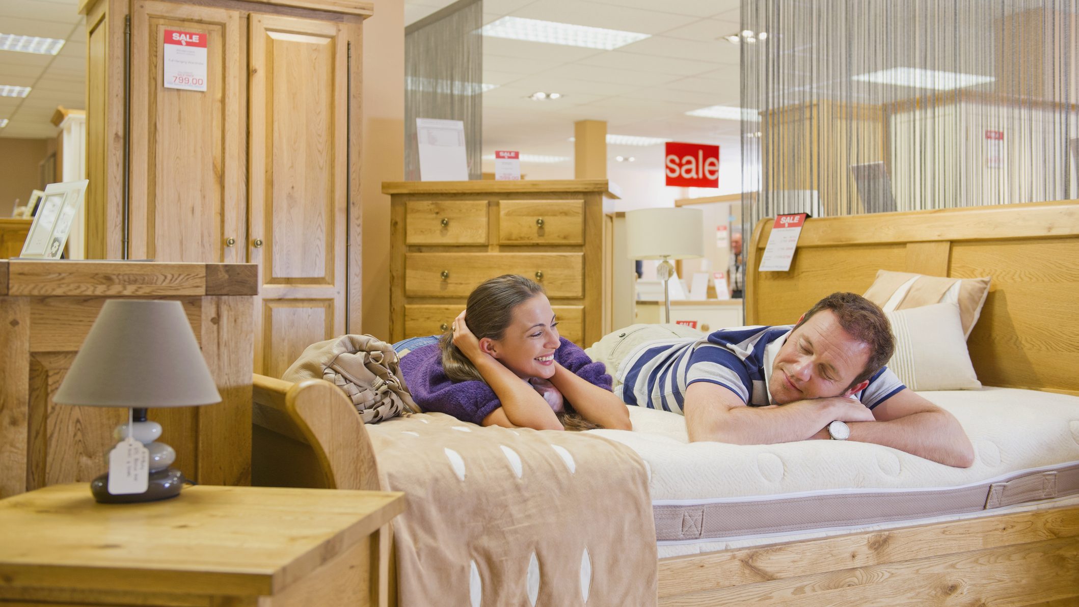 couple testing mattress in furniture store