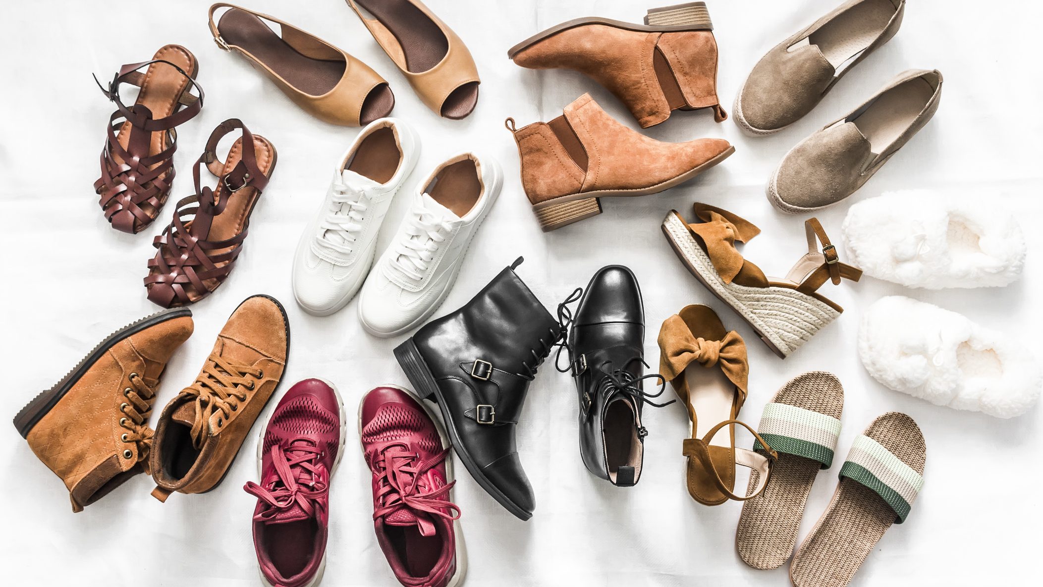 Variety of women's fashion comfortable shoes of all seasons on a light background, top view