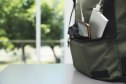 Smartphone charging with power bank in backpack on table, closeup. Space for text