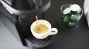 Close up of capsules coffee maker pouring an espresso in a cup