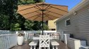 A backyard patio table with a large umbrella open above it for shade.