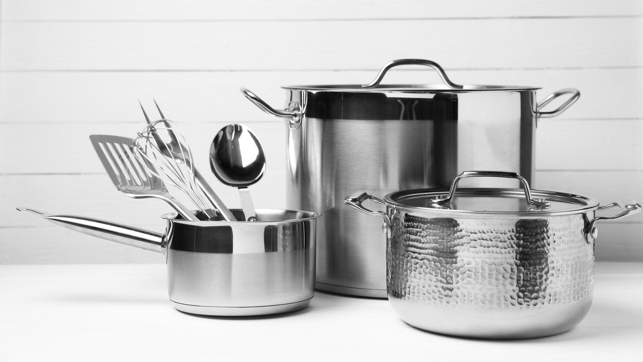 Dishware and cooking utensils on white table