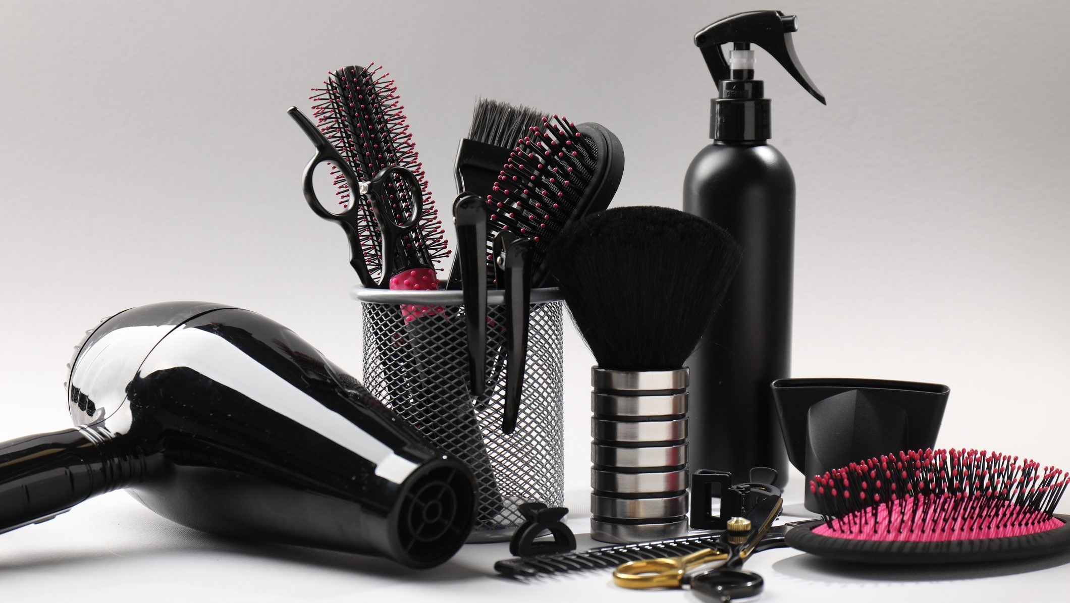 Different hairdresser's tools on light grey background, closeup