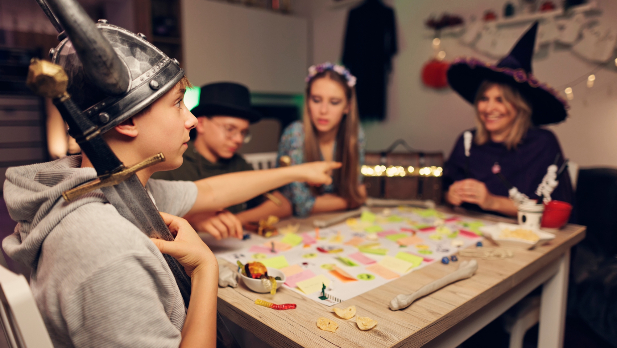 family around a table celebrating halloween by playing board games
