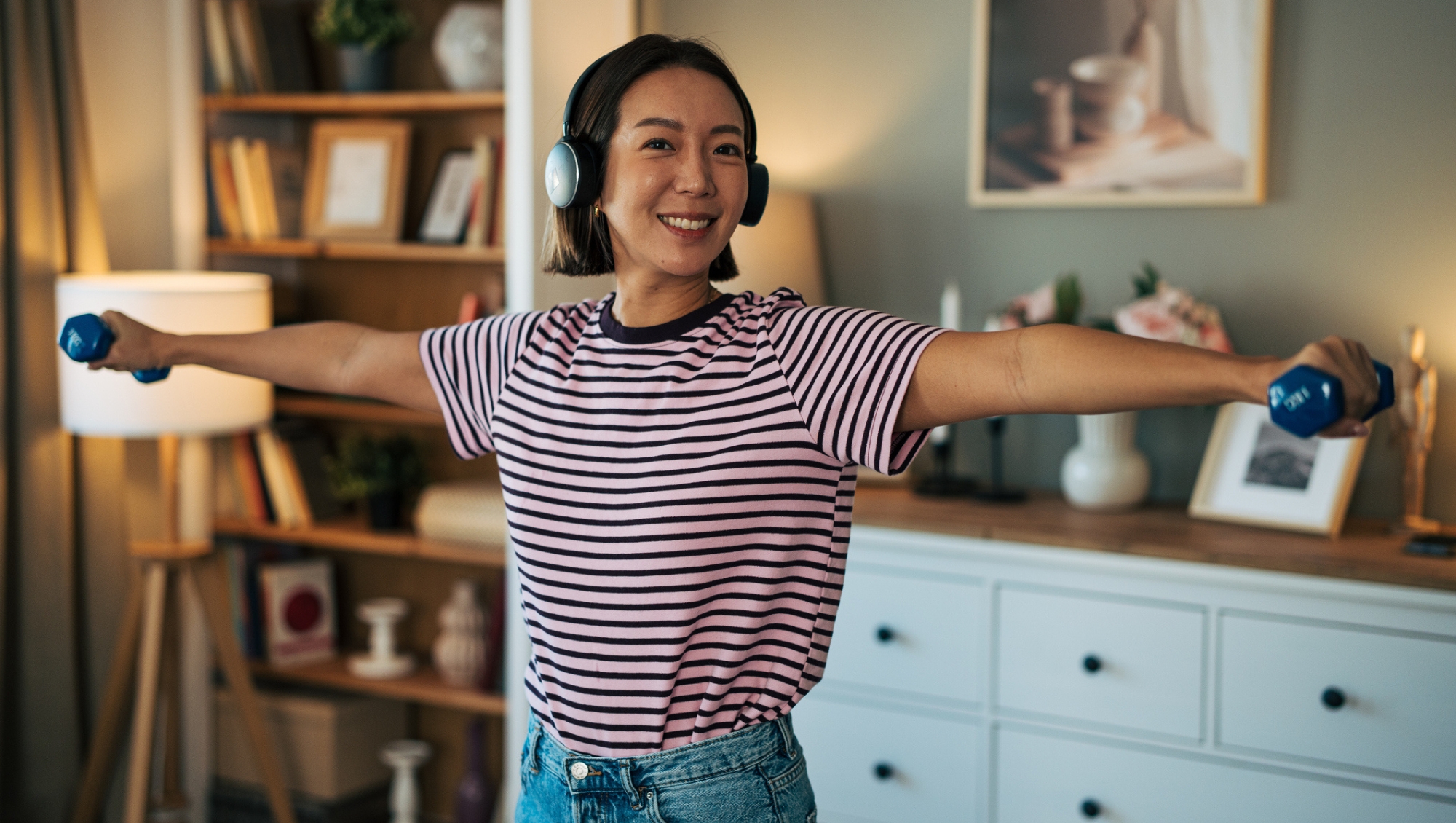 A woman using Affordable Amazon fitness finds, including dumbbells, resistance bands and yoga blocks