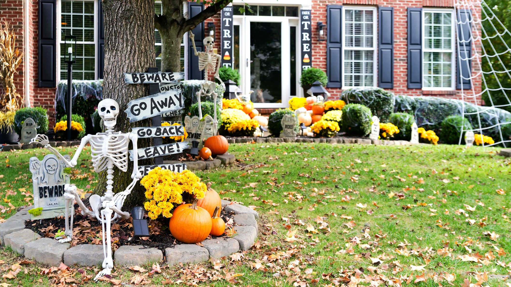 Skeletons, pumpkins and skulls are traditional attributes of Halloween in America. Frontyard decoration for Halloween party.Space for text.
