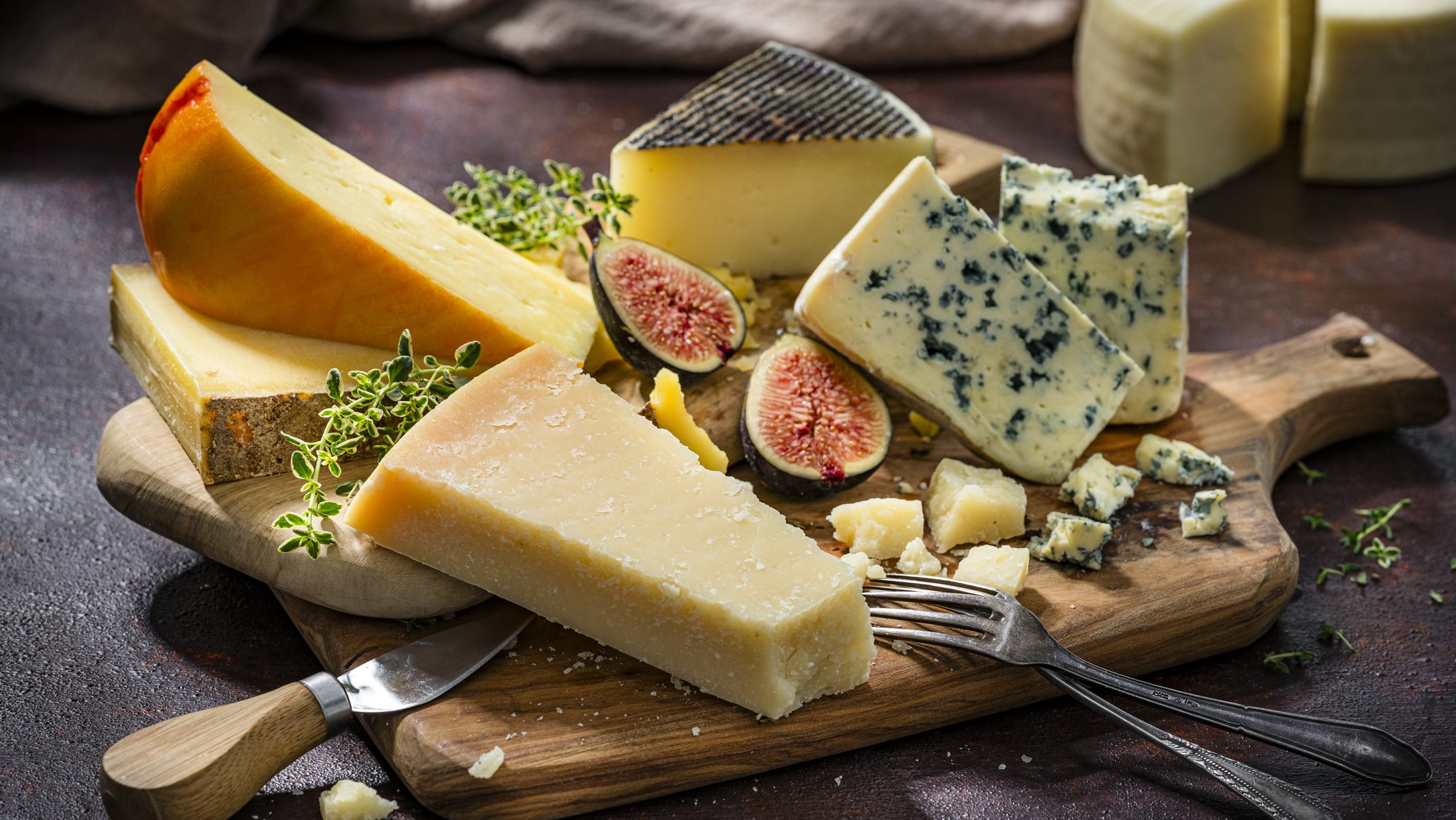 Board with a variety of cheeses: Parma cheese, blue cheese, Manchego cheese. French or Mediterranean food. Delicious appetizer for party or dinner